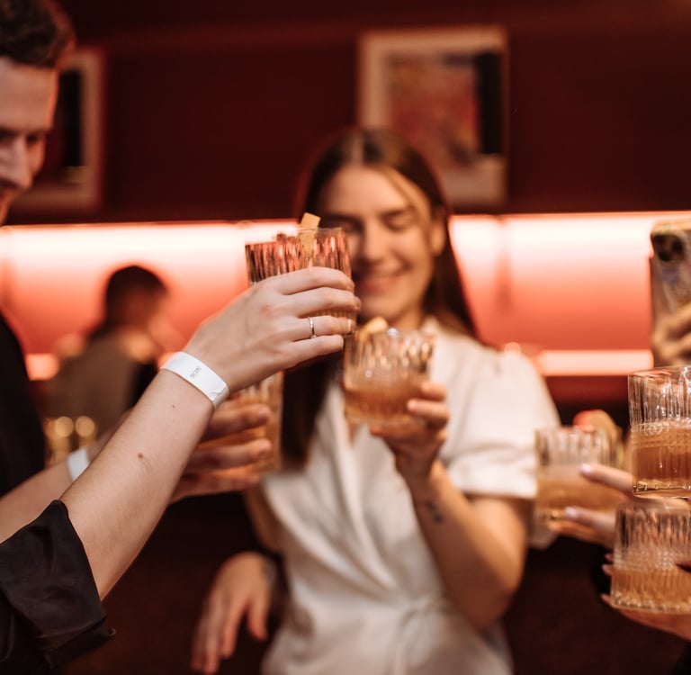 a group of people holding glasses and drinking wine