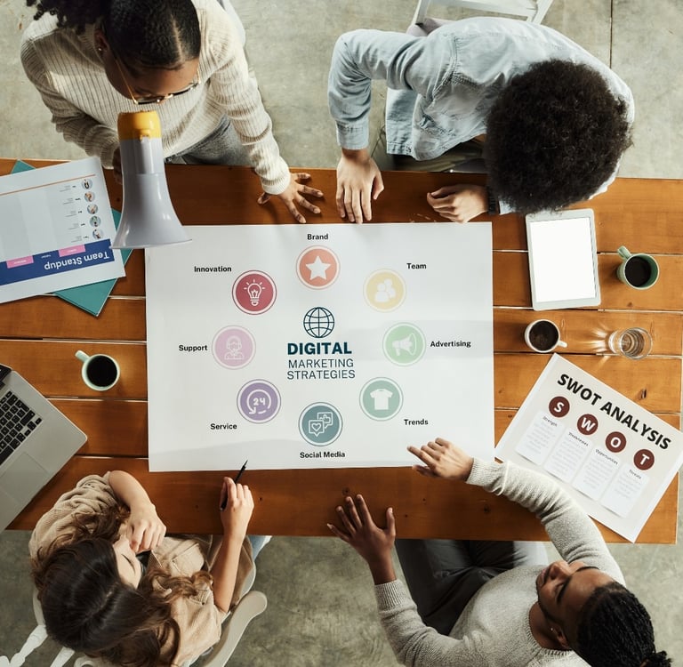a group of people sitting around a table with a laptop