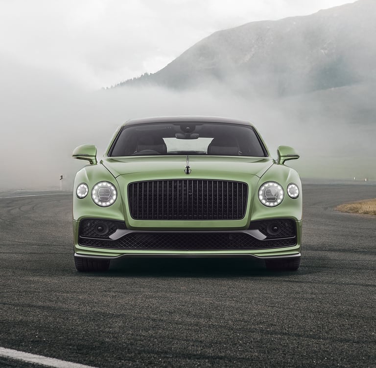 a green bentley flying spur in the swiss mountains