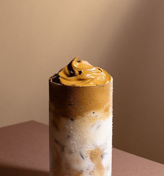 a glass of iced coffee with a cream 