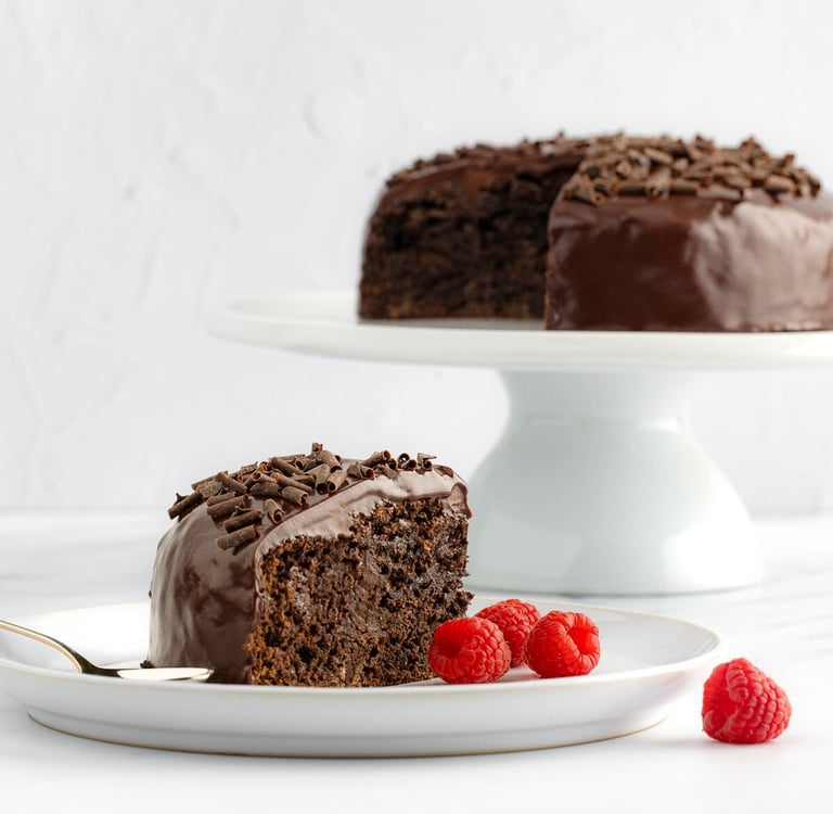 a slice of chocolate cake with chocolate frosting and raspberries