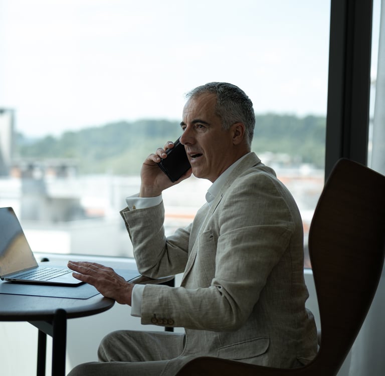 a man sitting at a table with a laptop and a laptop