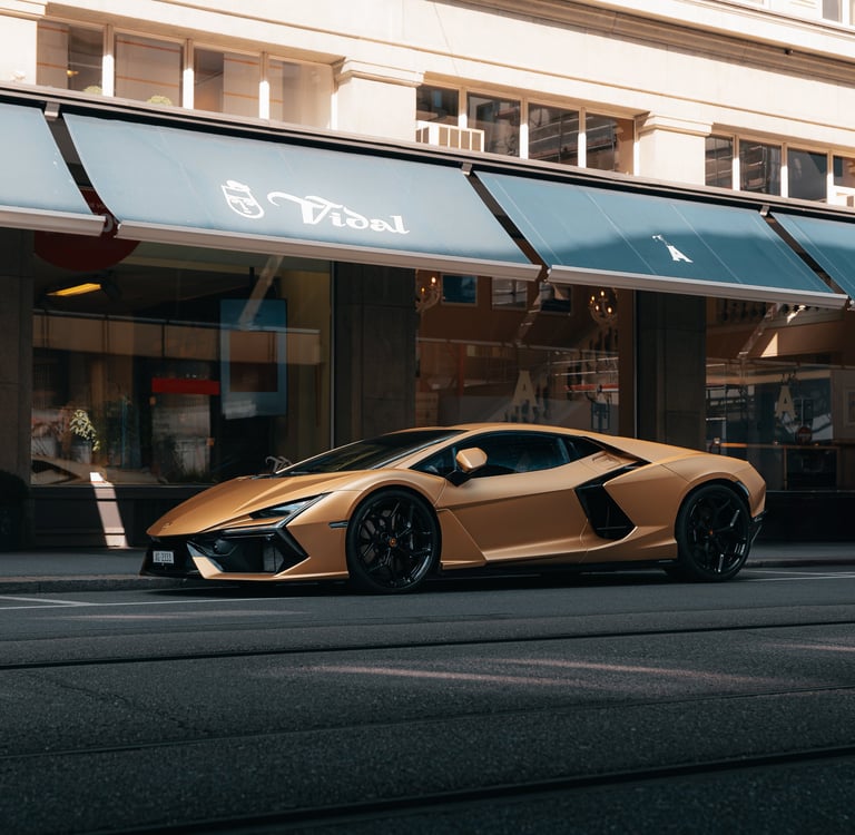 a gold colored lamborghini revuelto parked on the side of a street