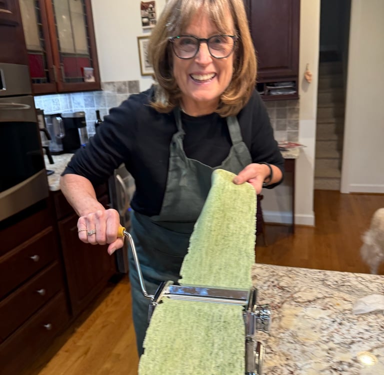 Class participant hand rolling spinach pasta noodle