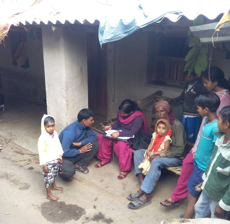 A community health worker interviews a rural family in India to collect survey data.