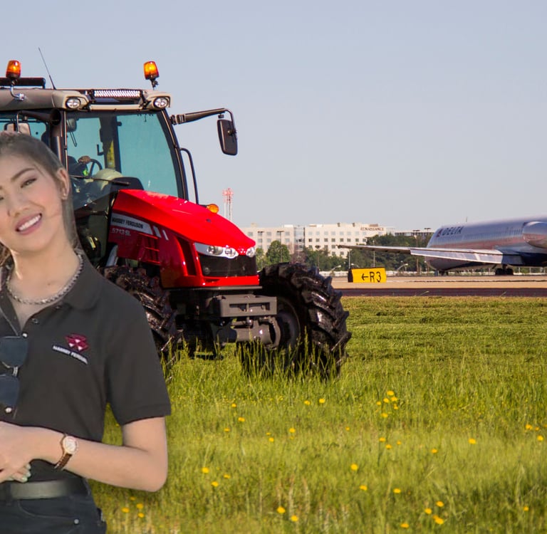 a woman in a black shirt and jeans standing in front of a tractor