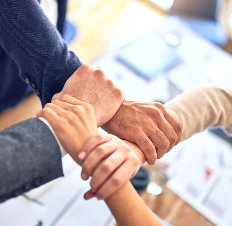 a group of people holding hands in a meeting room