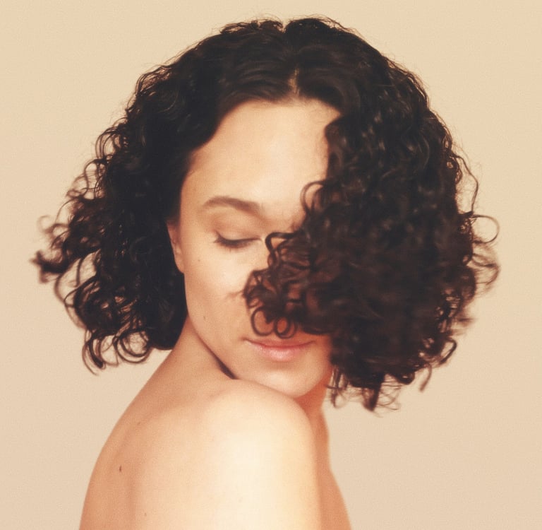 a woman with curly hair and a short haircut