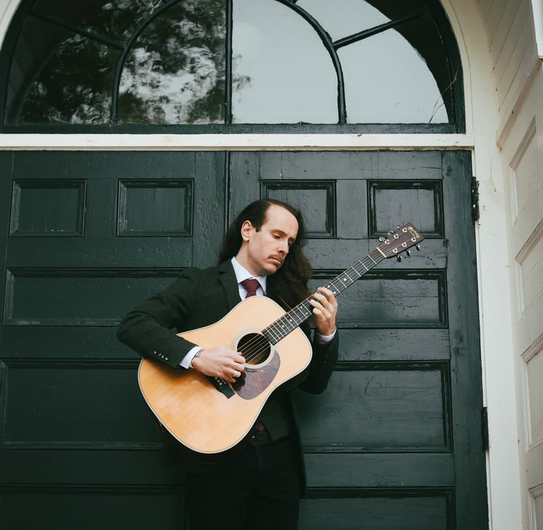 a man in a suit and tie playing guitar