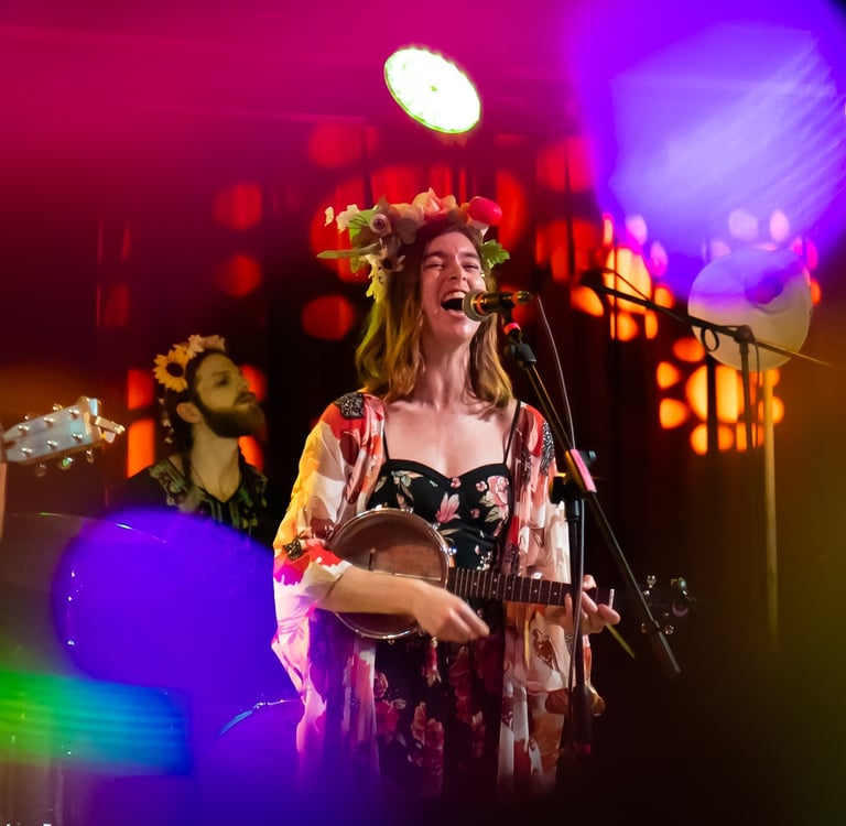 a woman singing and playing guitar in a band