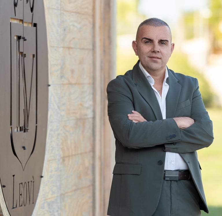 a man in a suit and white shirt standing in front of a clock