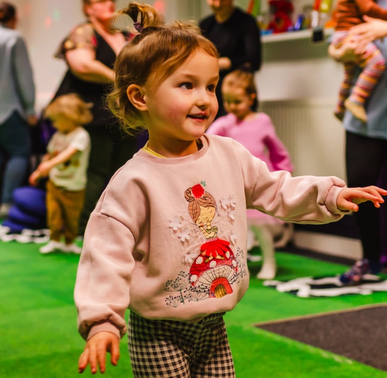 A young girl stood dancing in class for mixed moo.