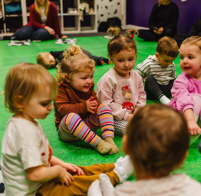 Young children as friends,sitting together watching farmer Becca in class. 