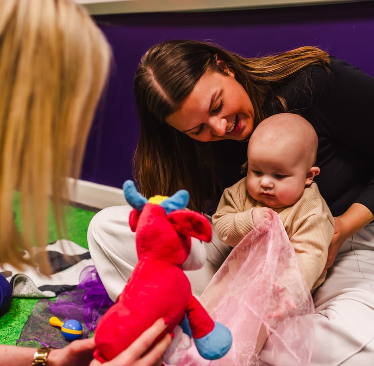 Mum looking over and smiling at her baby in Moo Music Worksop.