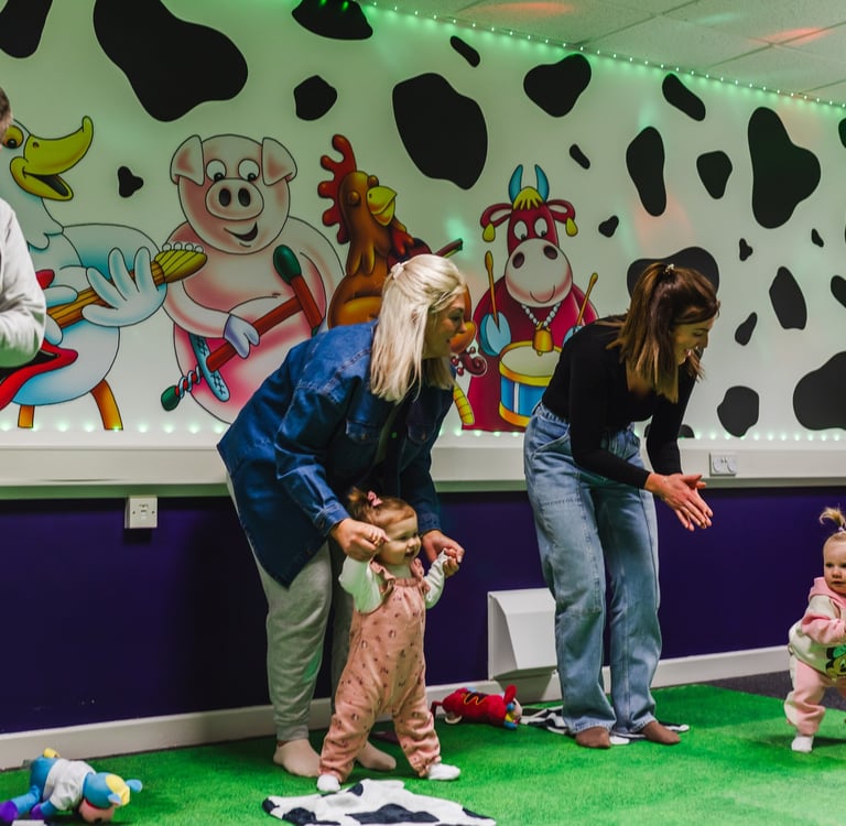 a group of parents, dancing with their children in moo music class. 