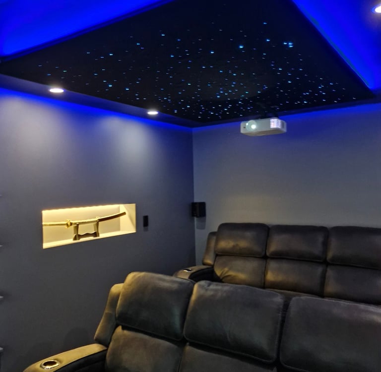 A cinema room with downlights and a star lighting ceiling