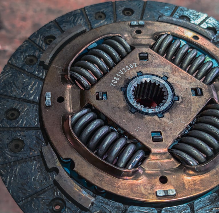 Close-up of a heavy-duty car clutch plate showing the metal friction disc and damper springs.