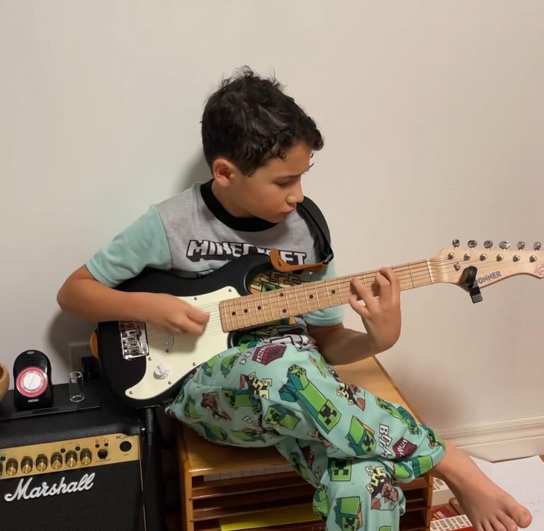 Boy playing guitar in his room