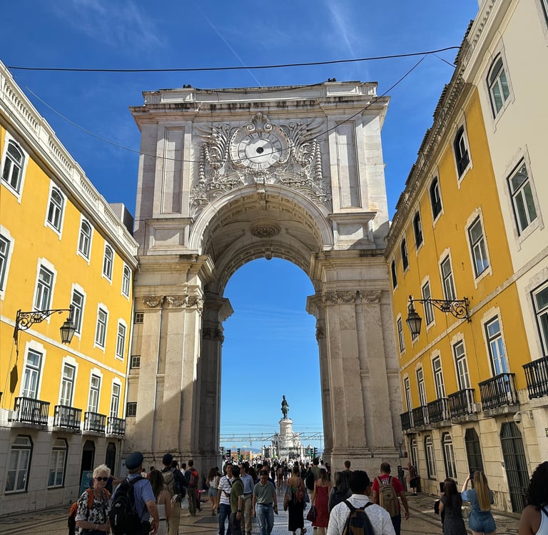 Duas paredes amarelas, conectadas por um arco de concreto que conta com uma escultura no topo 