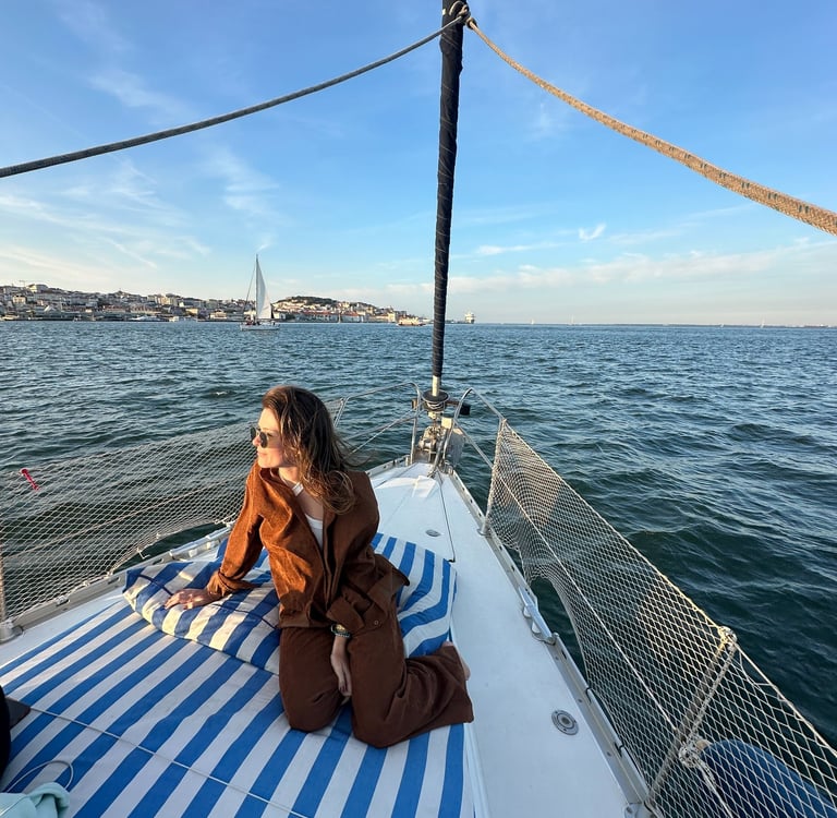 Pessoa sentada na ponta do barco, com a agua ao fundo