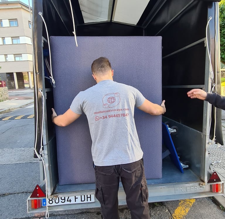a man is moving a couch into a moving truck