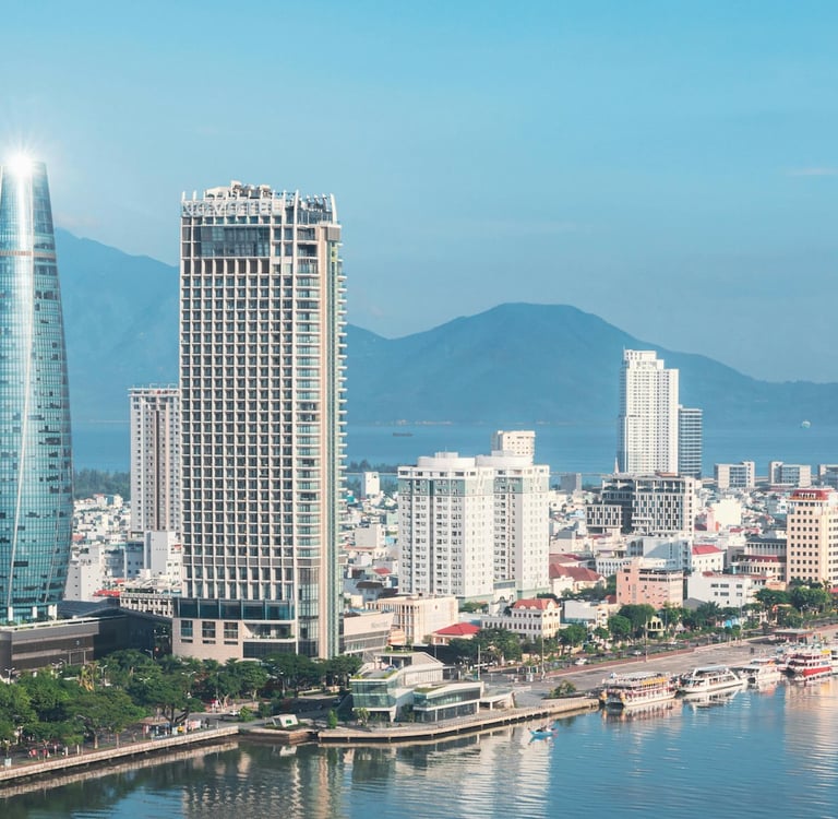 Da Nang city skyline with mountains, river, boats and buildings during the day
