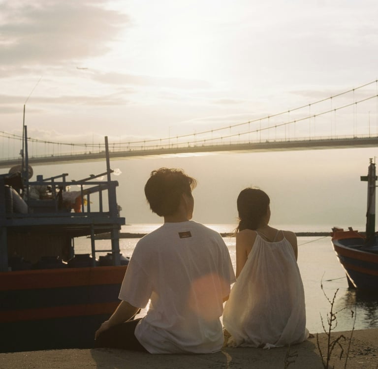 Couple sitting by the Han River in Da Nang, Vietnam