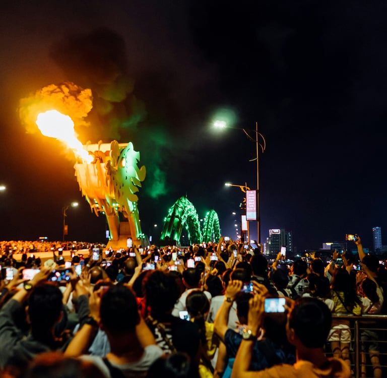 Crowd watching the Dragon Bridge fire show at night in Da Nang