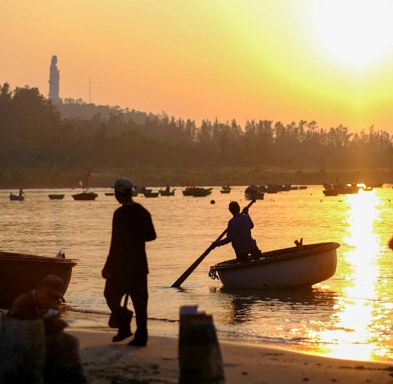 Local fishermen on Da Nang beach at sunrise with basket boat