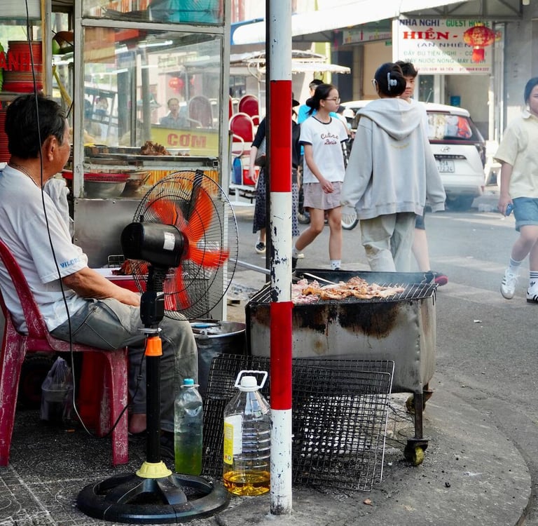Local street food vendor cooking over charcoal in Vietnam