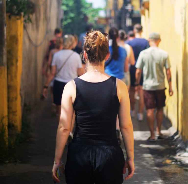 Woman walking down a busy alleyway in Vietnam