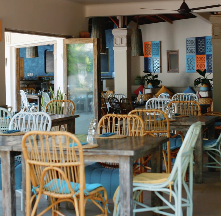 Empty cafe interior in Vietnam with bamboo-style chairs, cushions and simple tables