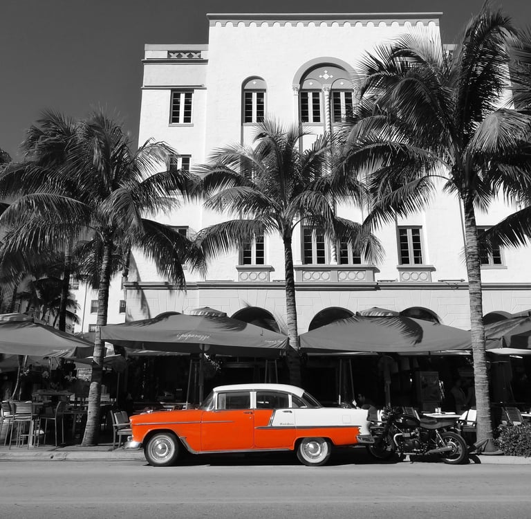 a classic red car parked in front of an art deco building