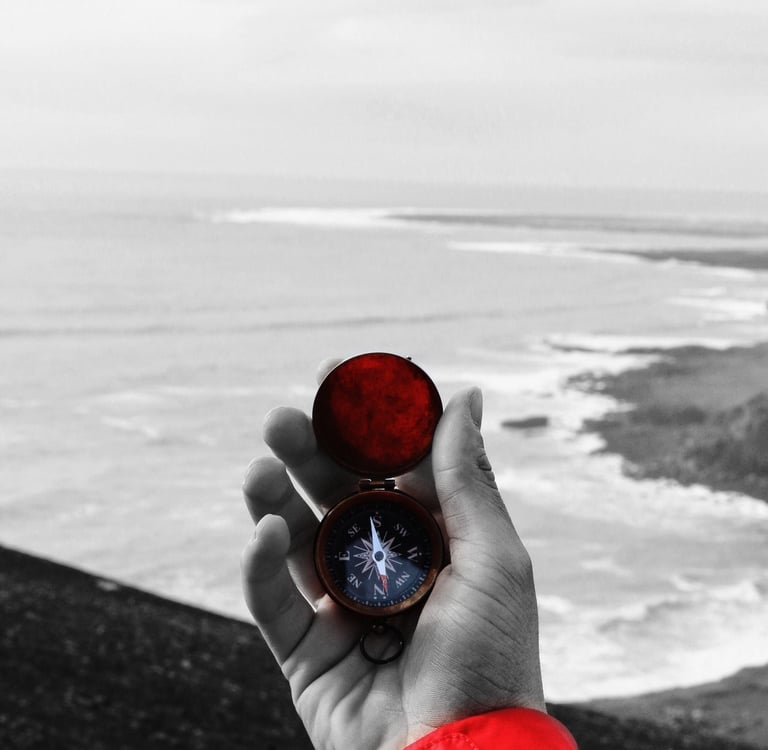 a person holding a compass on a beach
