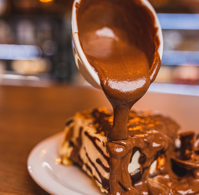 a person holding a cup of coffee and a piece of cake