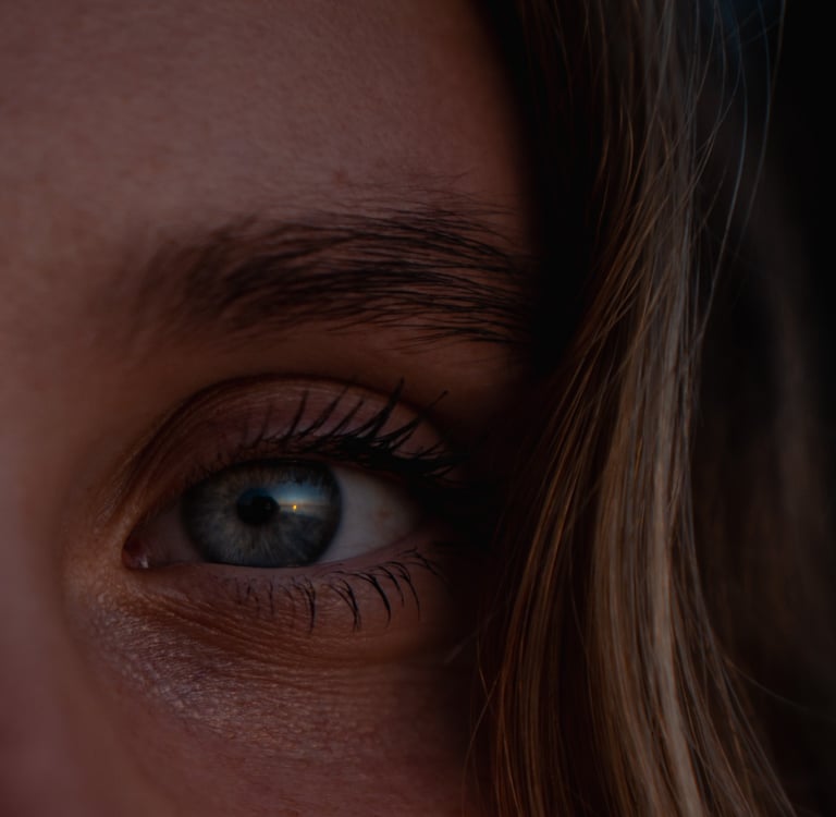 a woman with blue eyes and a toothbrush in her mouth