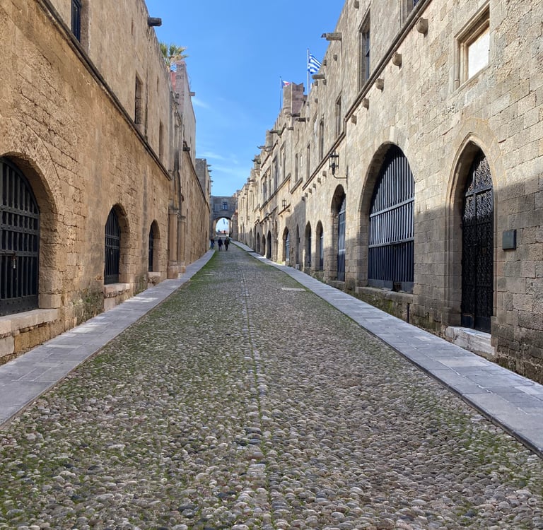Medieval Street of the Knights with cobblestone path and stone arches in Rhodes Old Town, Greece.