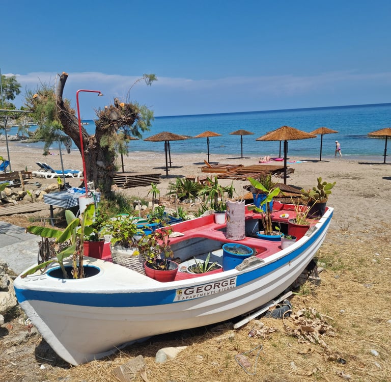 a boat sitting on the beach with umbrellas