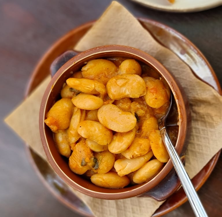 A bowl of Greek Gigantes Plaki, large butter beans baked in a savory tomato sauce.