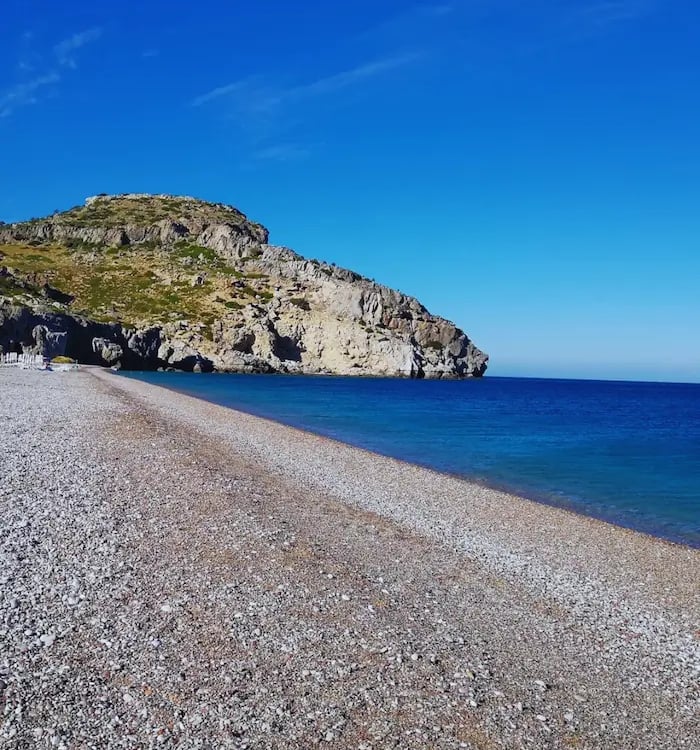 a beach with a rocky beach and a blue sky