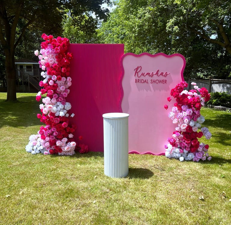 a hot pink and white floral bacldrop for a bridal shower outside