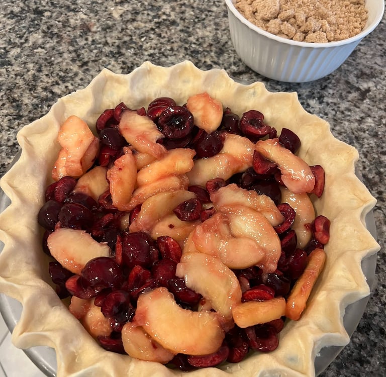 cherries and peaches in an unfinished pie shell