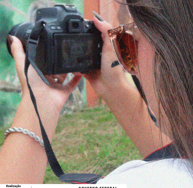 Uma mulher segurando uma câmera fotográfica