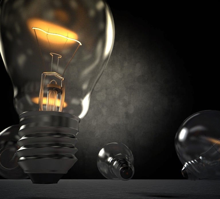 Zbliżenie na żarówkę. Na ciemnym tle dokładnie widać rozgrzany żarnik