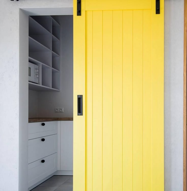 Drzwi przesuwne w kolorze żółtym, oddzielające kuchnię od pozostałej części mieszkania