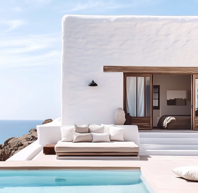 Luxury Mediterranean villa with white stucco walls, an outdoor daybed, and a private infinity pool overlooking the ocean.