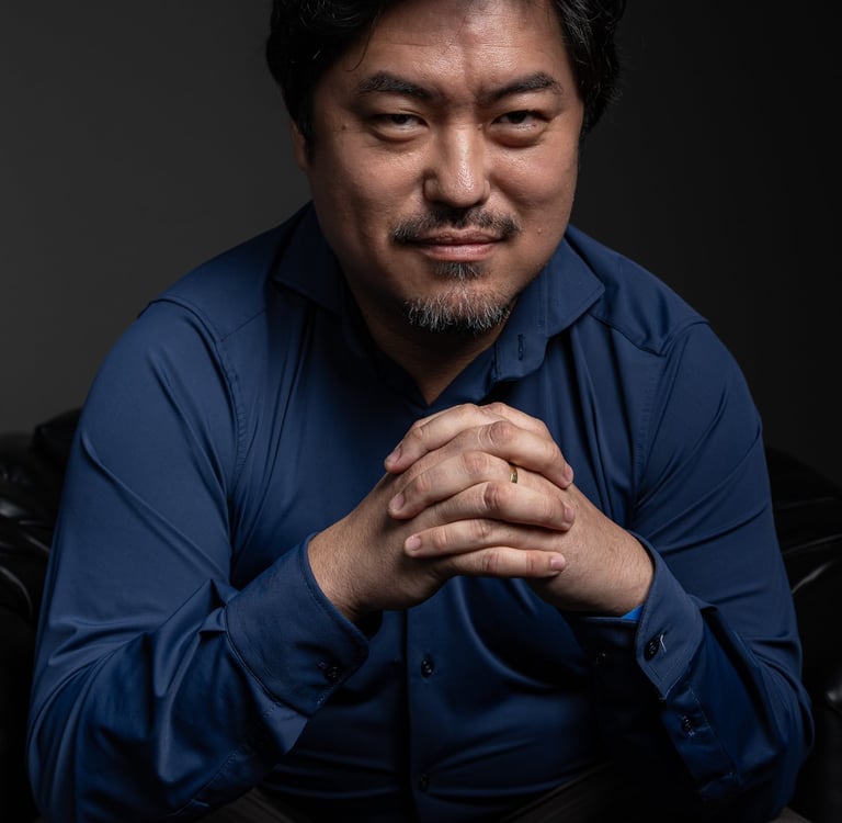 Retrato corporativo masculino em Barueri: close em estúdio com fundo escuro, expressão confiante