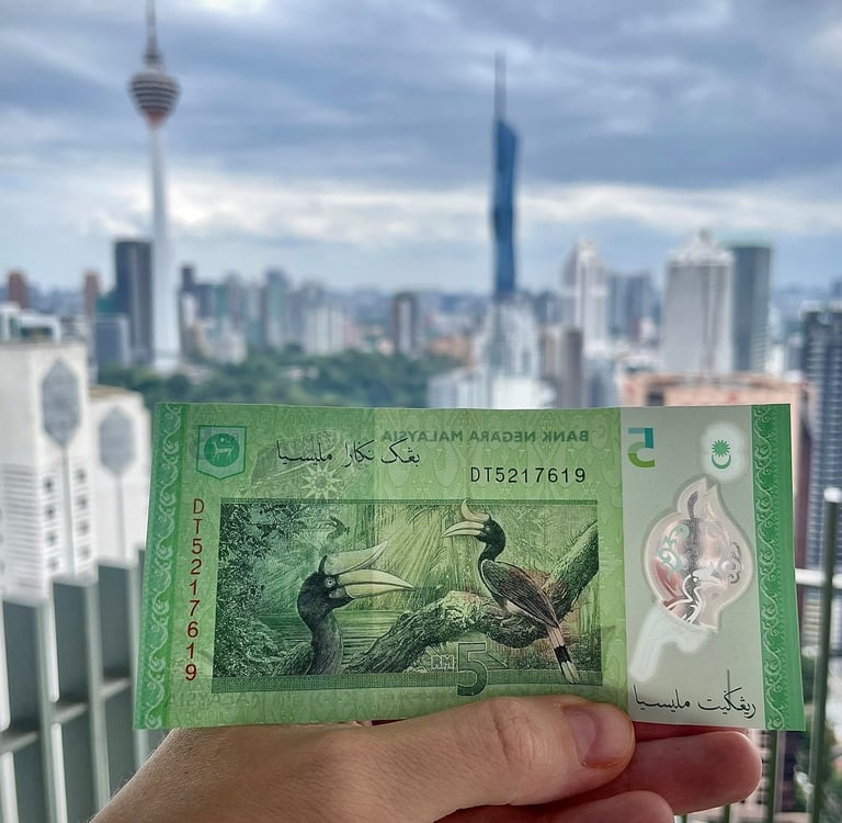 malajskie pieniądze na tle Kuala Lumpur