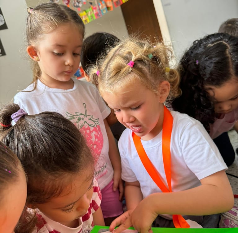 Niña mostrando a sus compañeros imagenes en jardín infantil Ukelele