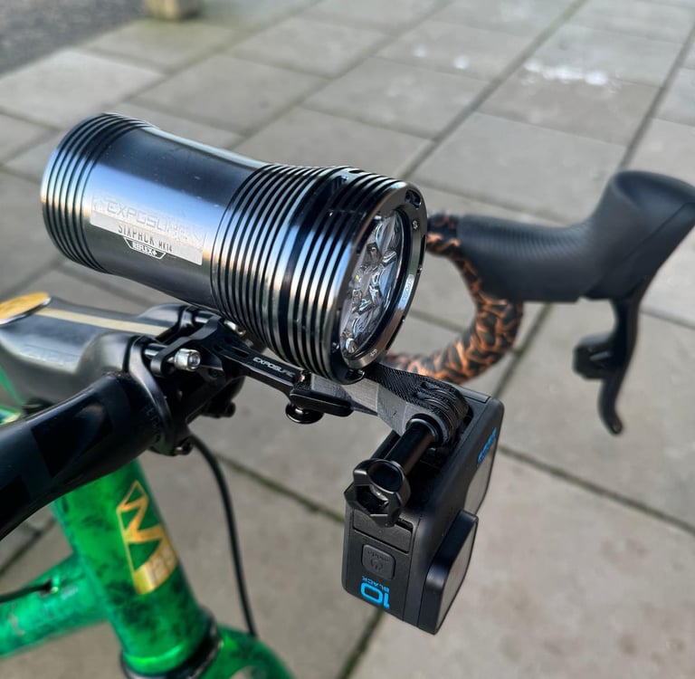 Exposure Six Pack front bike light and GoPro Hero 10 mounted on bicycle handlebars for night riding.